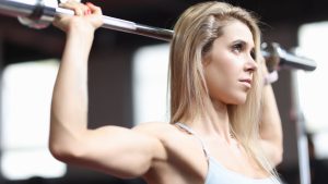 Portrait of an Athletic Woman Performing Pull-Ups on Bar