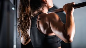 Woman doing pull ups during a gym workout. 